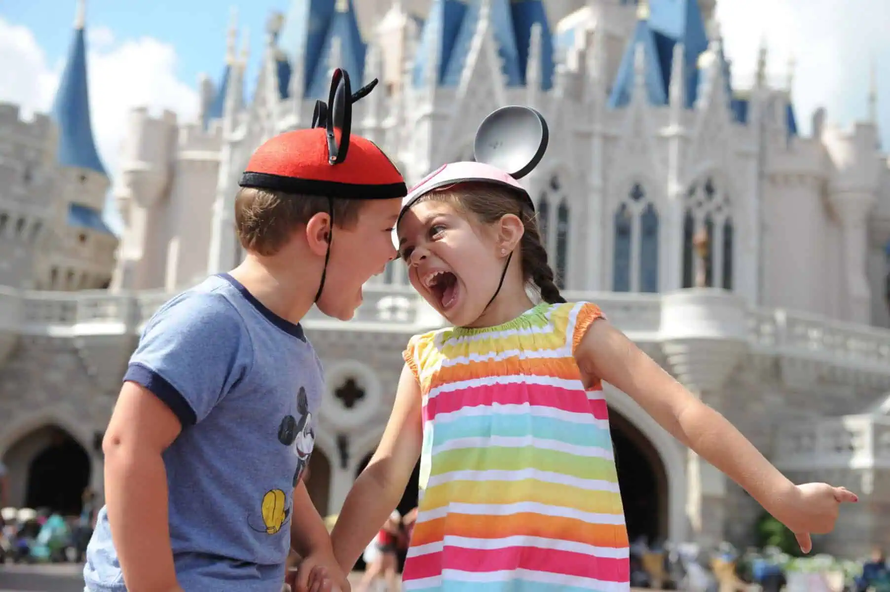 Illustration for Walt Disney World Planning — a boy and girl wearing Mickey ear hats, holding hands and smiling at each other with the back of Cinderella Castle in the background.