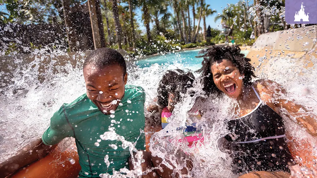 Happy family getting splashed on a raft water slide
