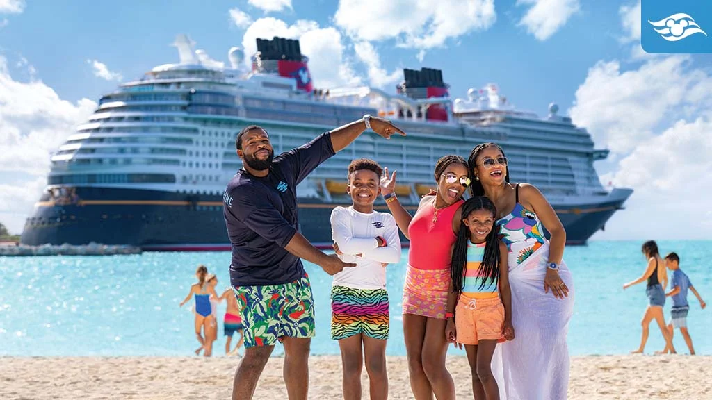 family having fun on the beach with disney cruise ship in the background